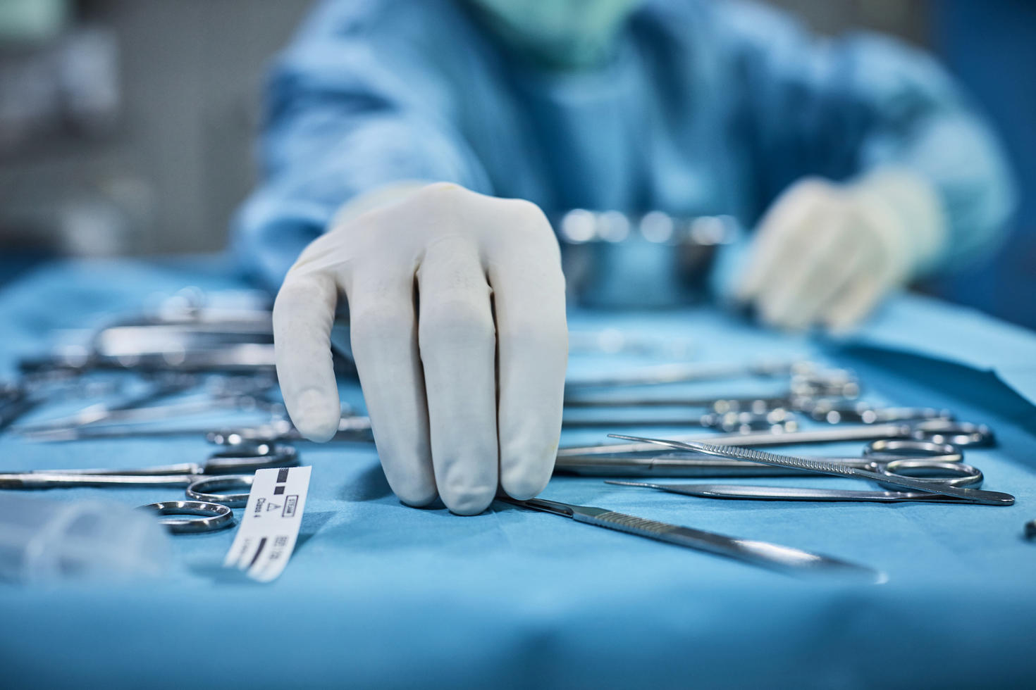 Surgeon picking up surgical tool from tray