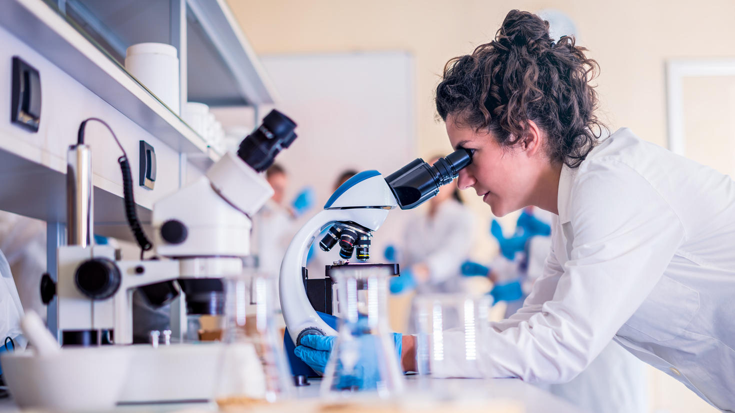 Female researcher looking in microscope