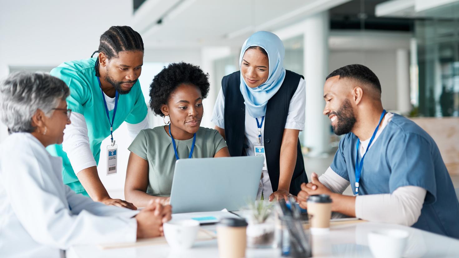 A team of doctors sitting around a laptop