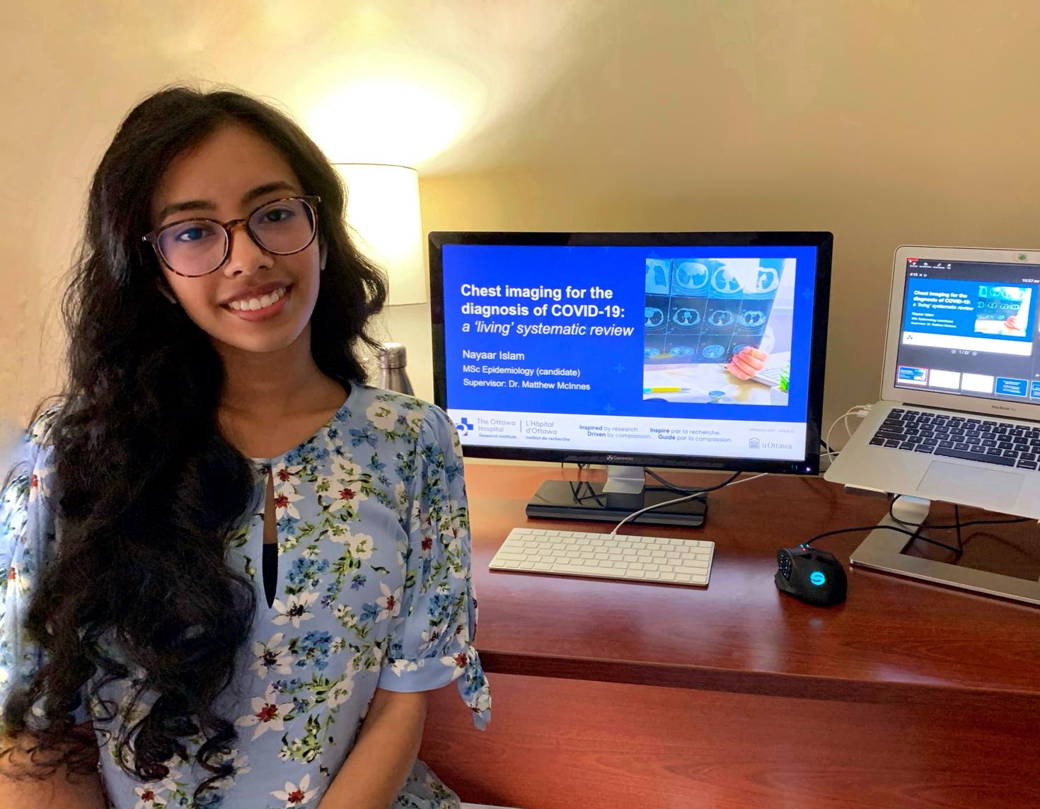 Nayar Islam in front of computer indicating winning award