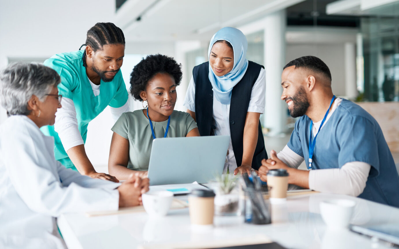 A team of doctors sitting around a laptop