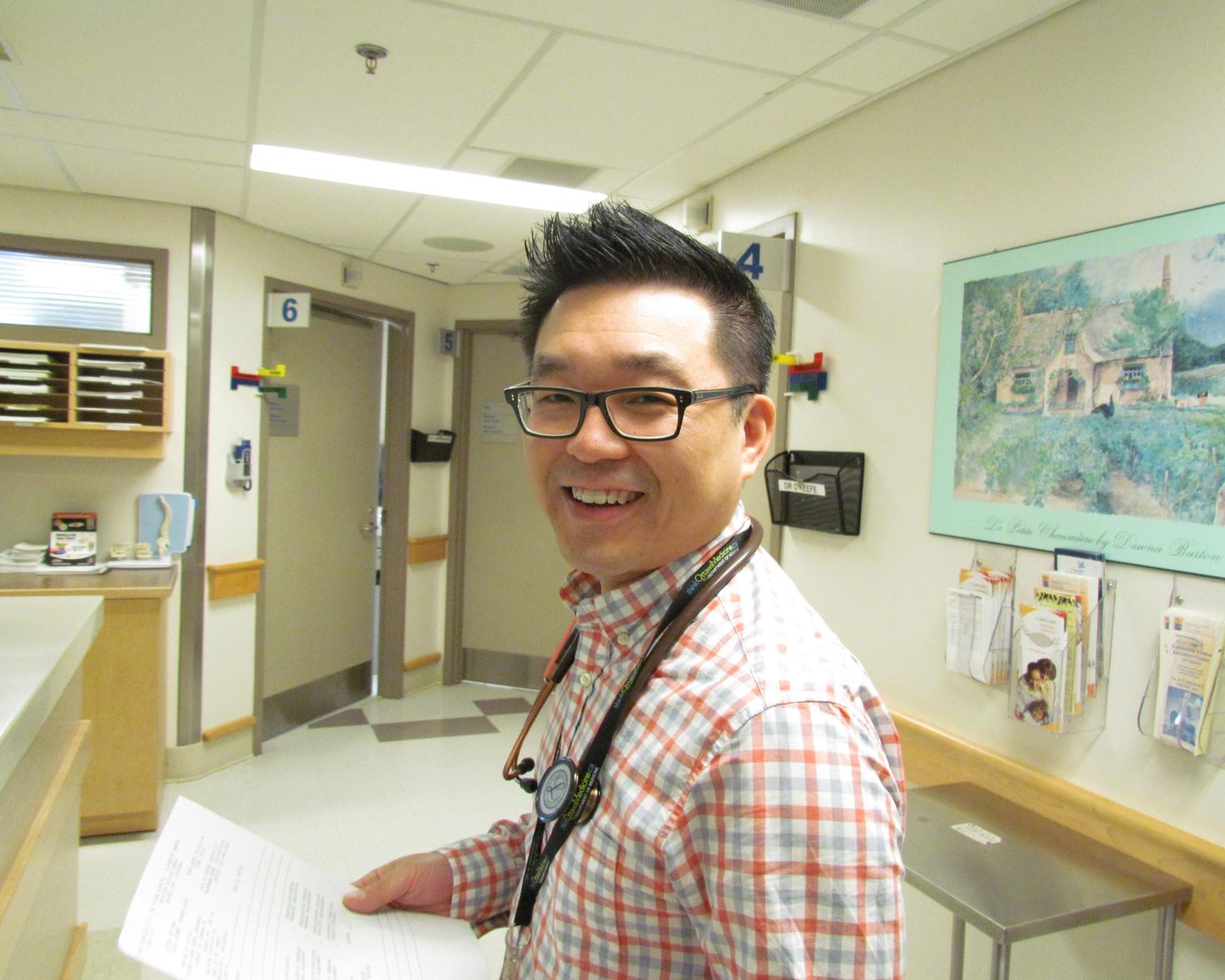 Dr. James Chan smiling with a document in his hand