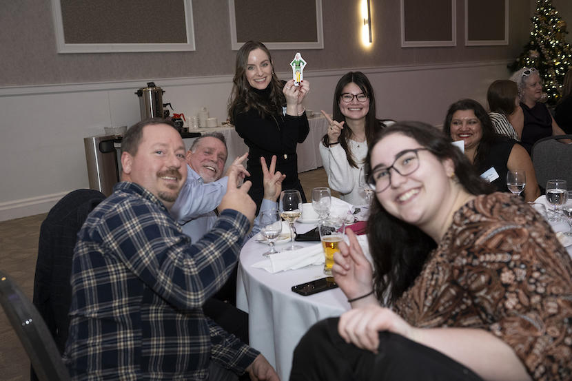 a group of staff members sitting at a table and smiling