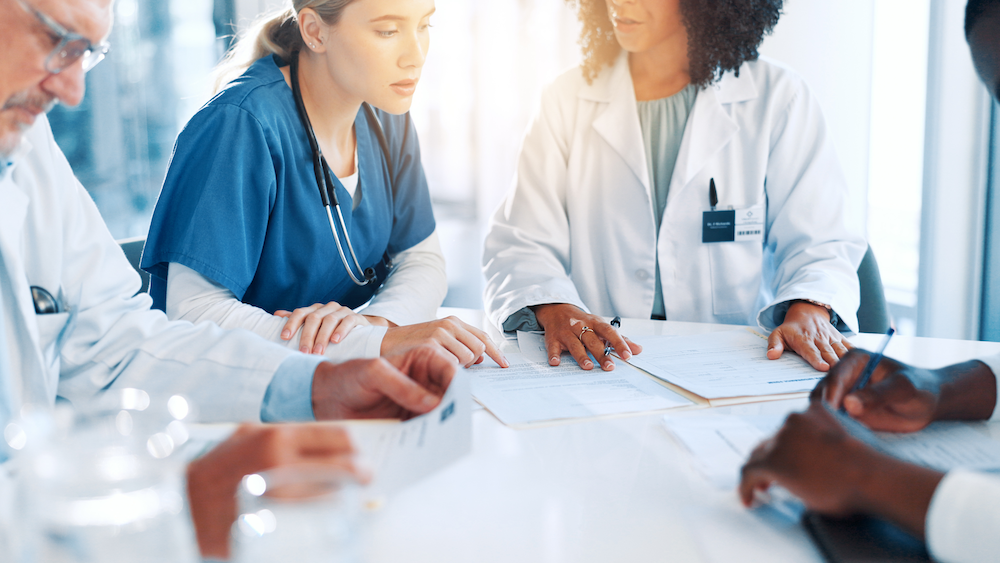 medical professionals sitting around a table talking