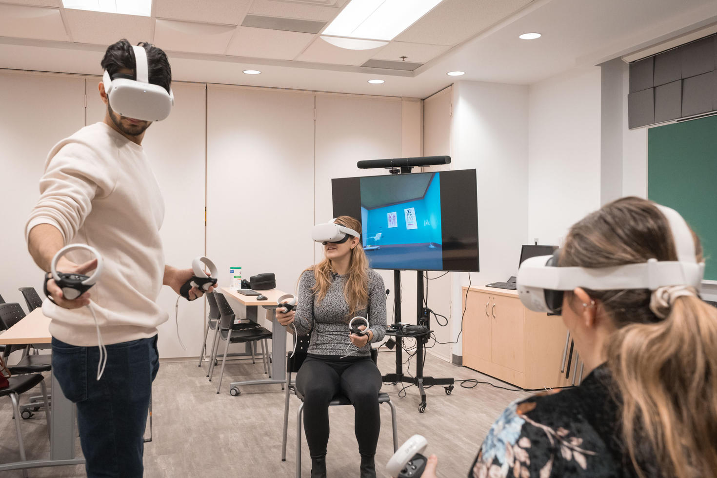 Three learners using virtual reality headsets in a classroom