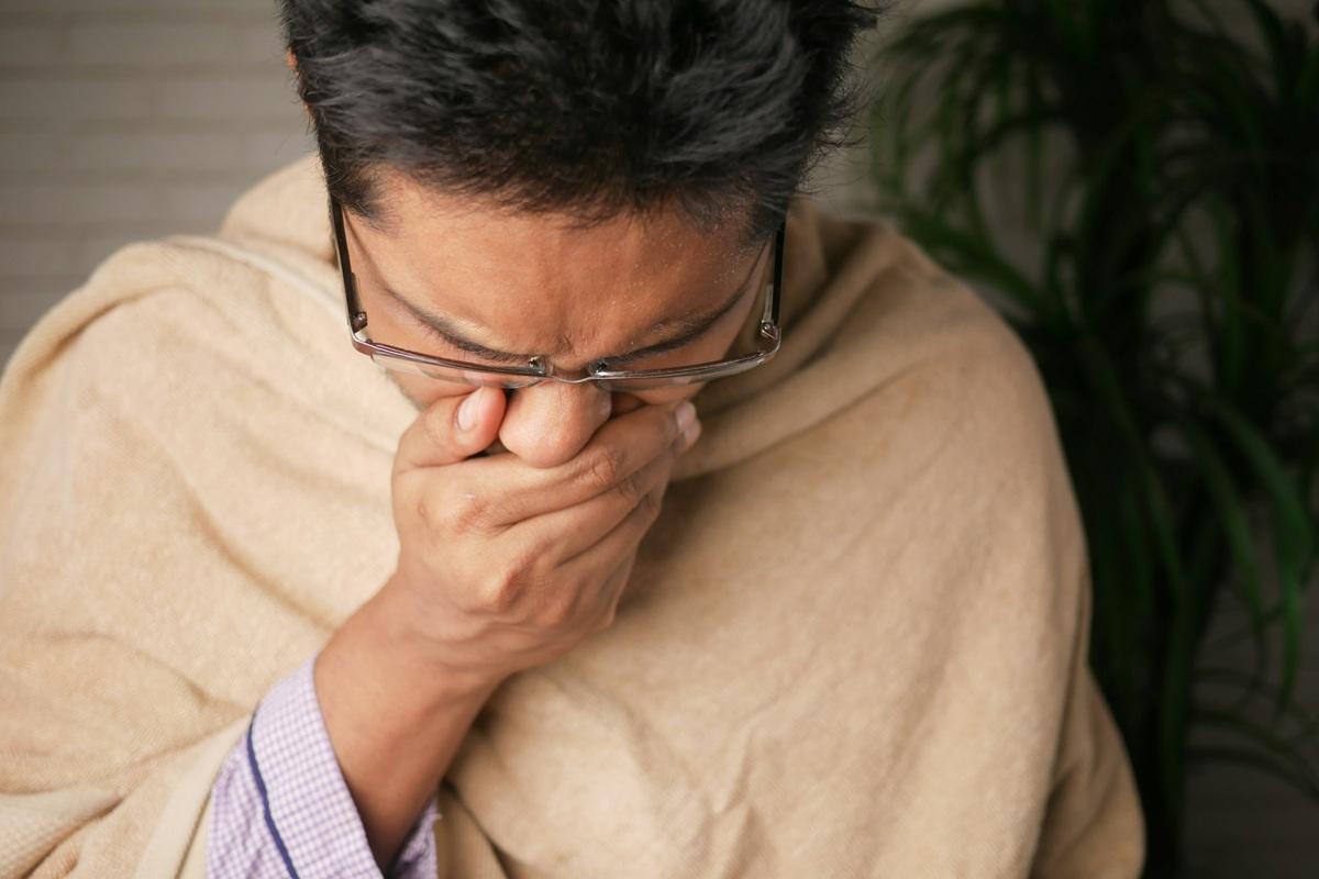 Man holding nose during sneeze