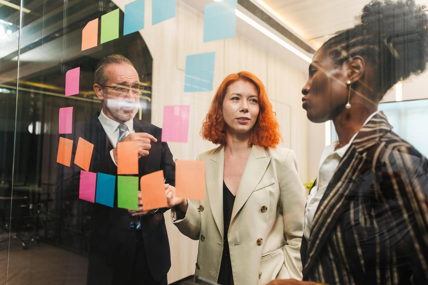 People brainstorming in front of a board covered with sticky notes