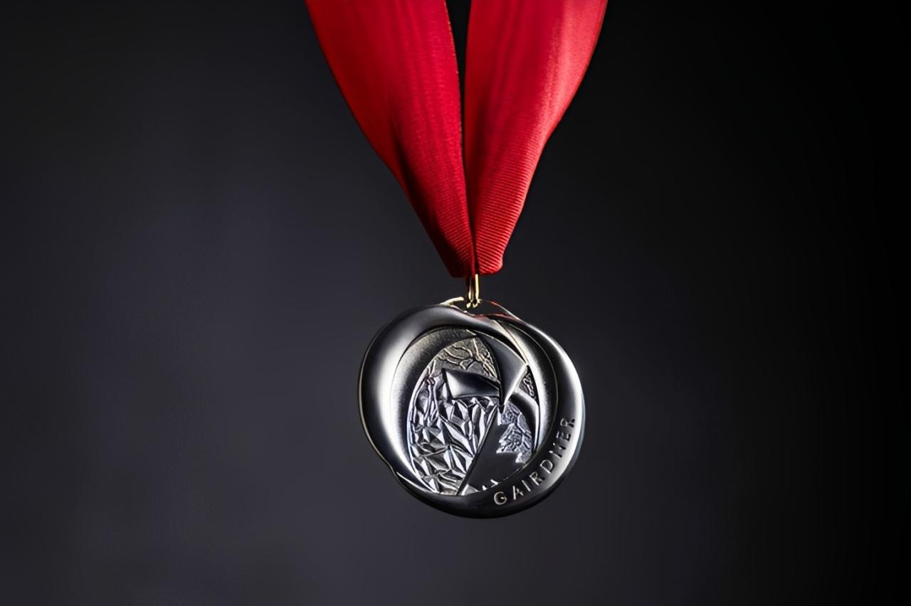 A silver Gairdner award medal engraved with the word “GAIRDNER,” suspended from a red ribbon.