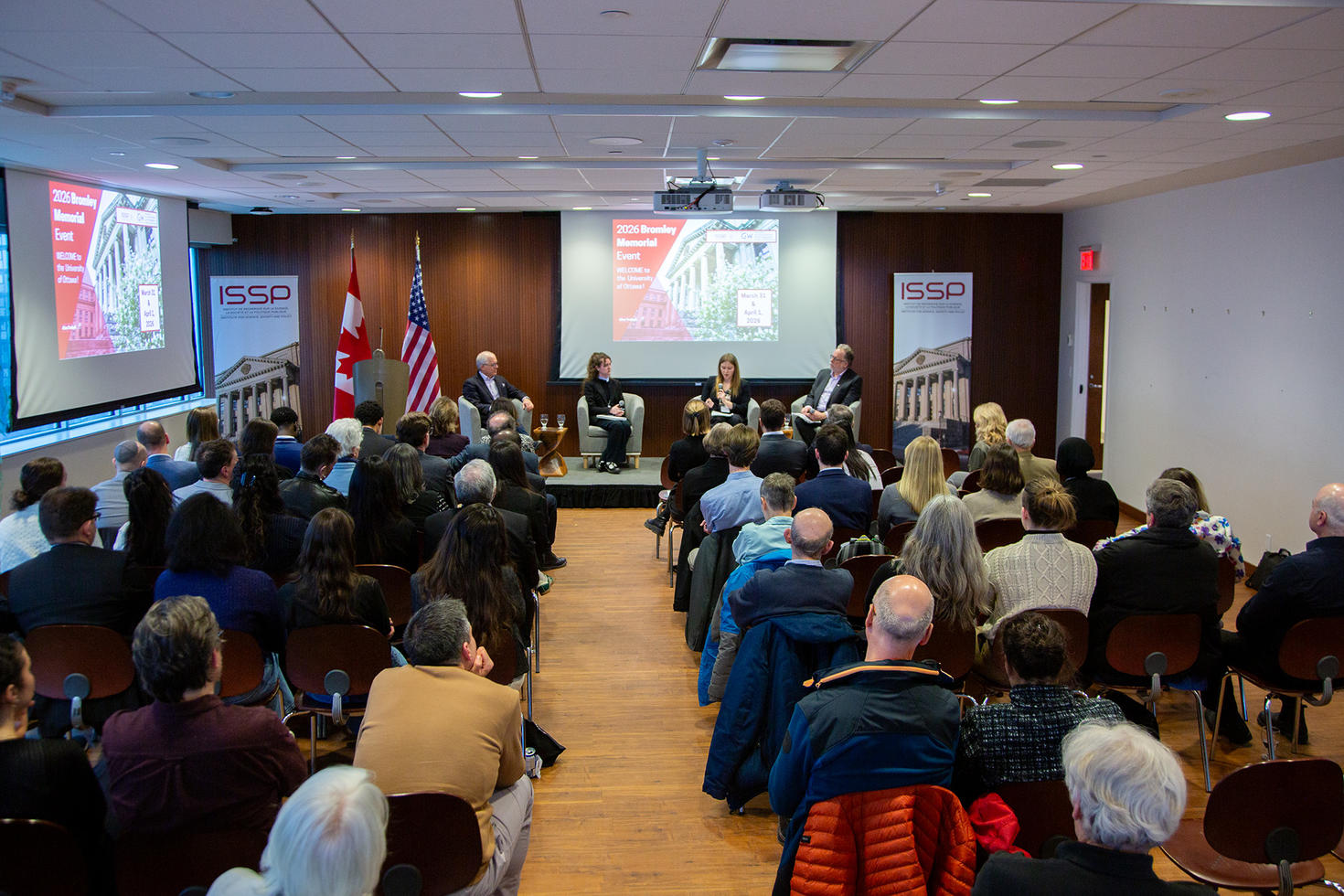 View of the Bromley Memorial Lecture's panel on stage and audience from the back of the room