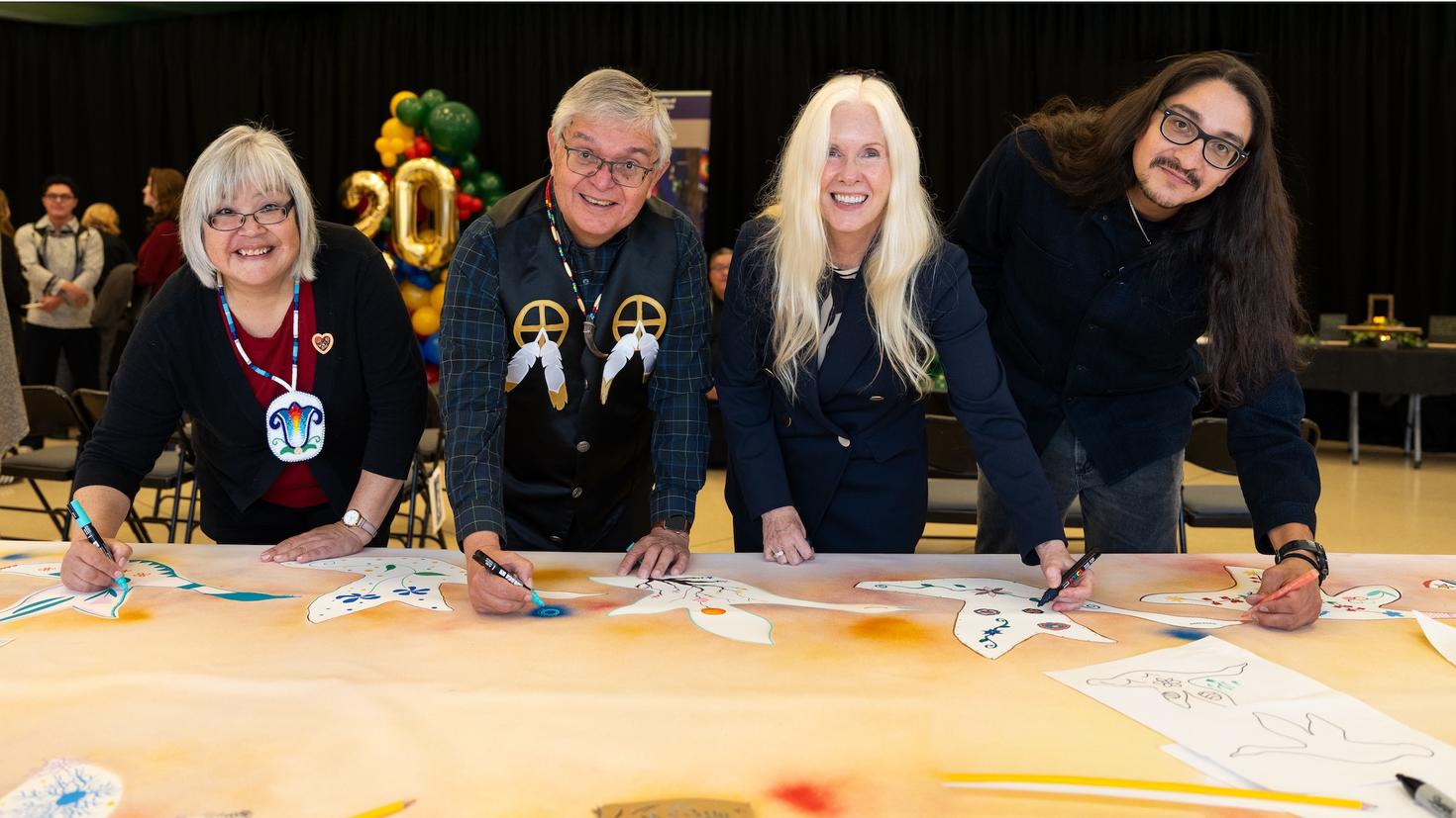 Simon Brascoupé working on mural artwork with Dr. Darlene Kitty, Melissa Forgie and Dr. Alex Petiquan
