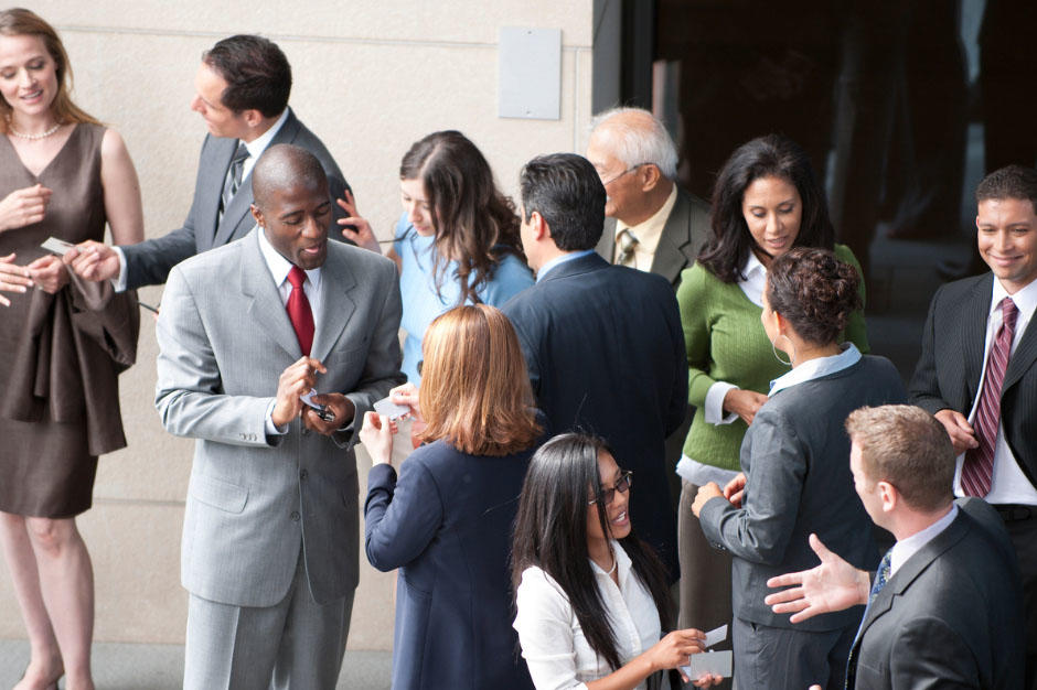 A group of professionals interacting together in various smaller groups.