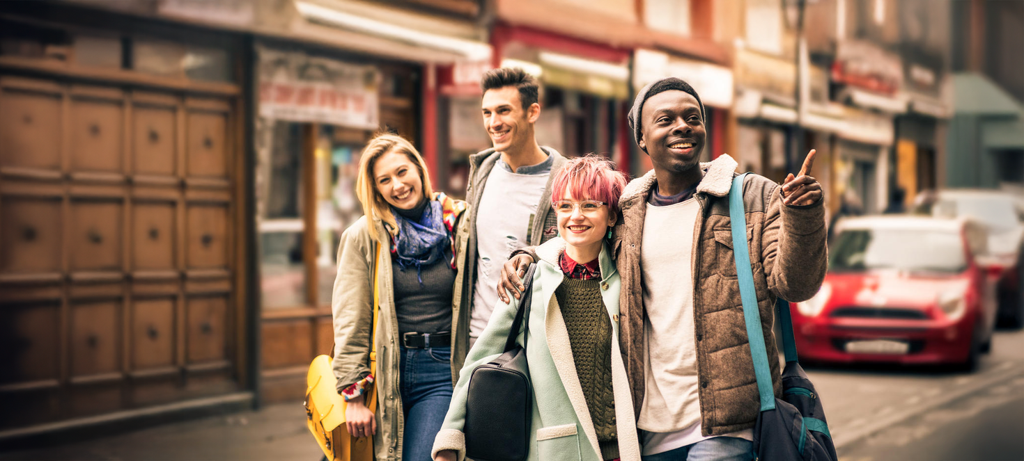 Happy multiracial friends walking on Brick Lane at Shoreditch London
