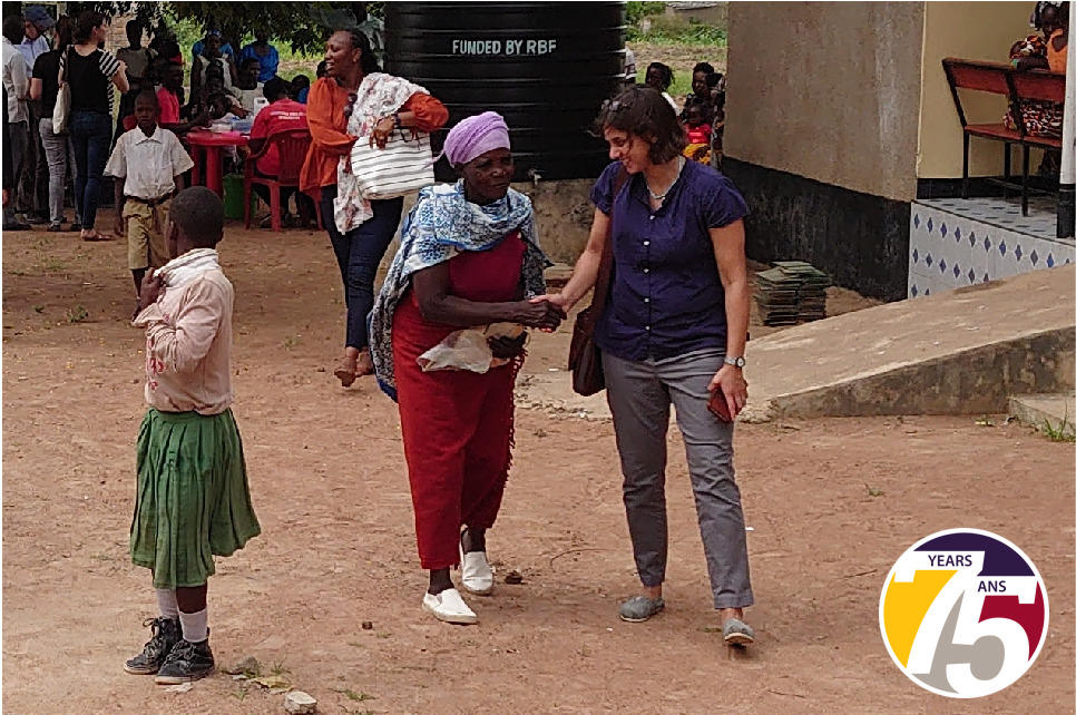dr. Manisha Kulkarni speaks with a woman in a Tanzanian village.