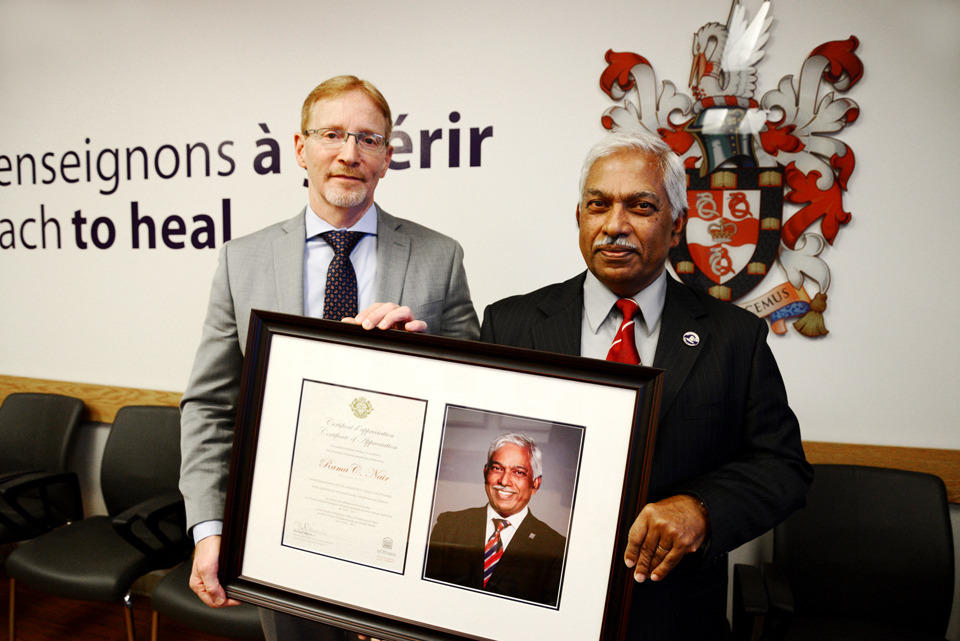 Dr. Bernard Jasmim presents a certificate to Dr. Rama Nair.