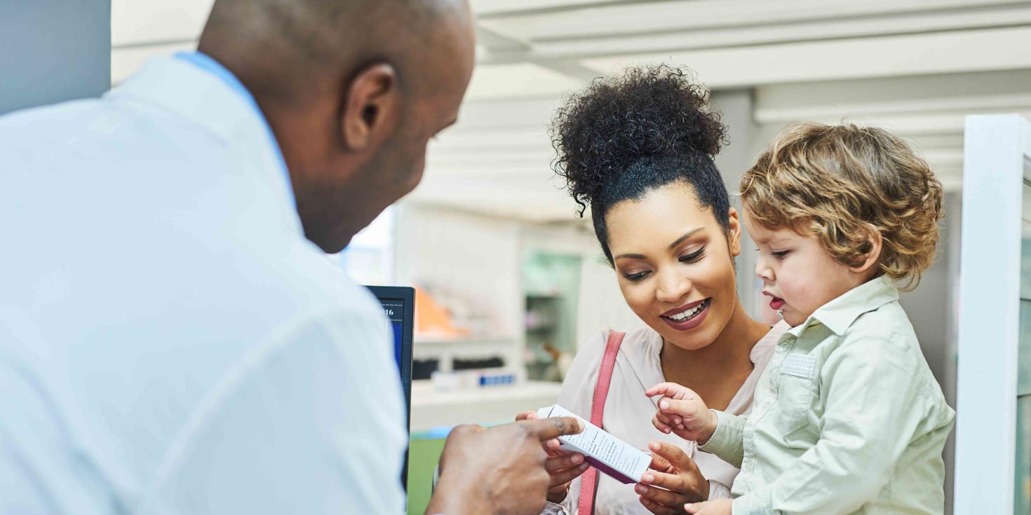 Pharmacist explaining the use of a medication to a mother and her toddler