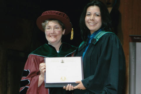 Kona Williams receives her MD diploma from Dr. Senterman at a convocation ceremony