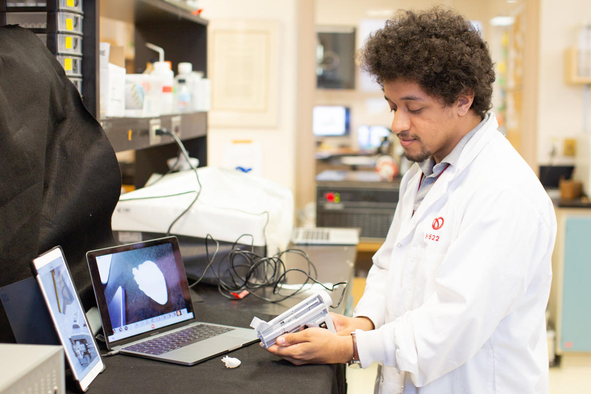 Maxime Comtois-Bona demonstrating the patch-printing device on a tiny 3D-printed heart.