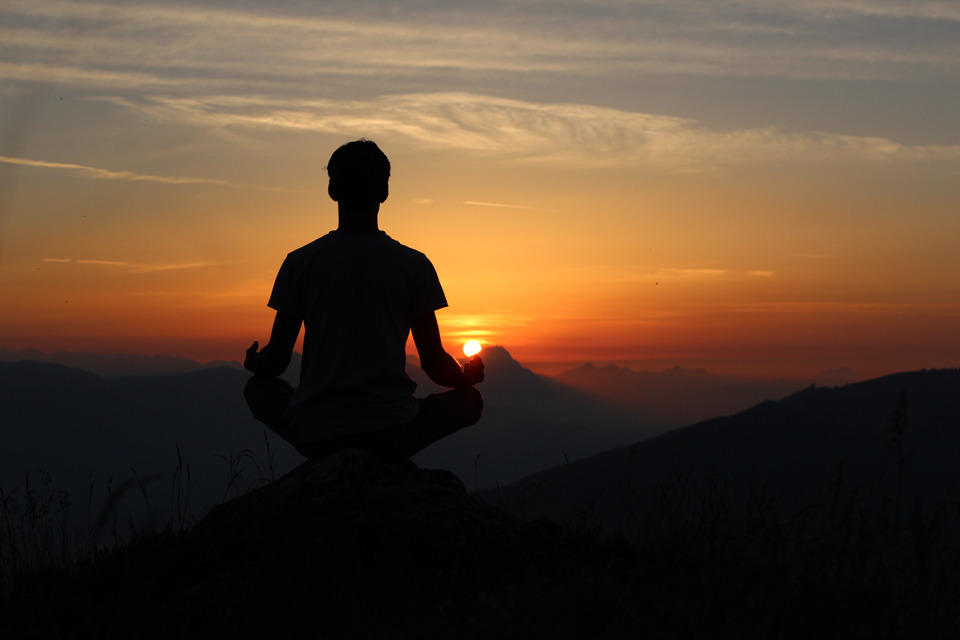 a man meditating on a mountain