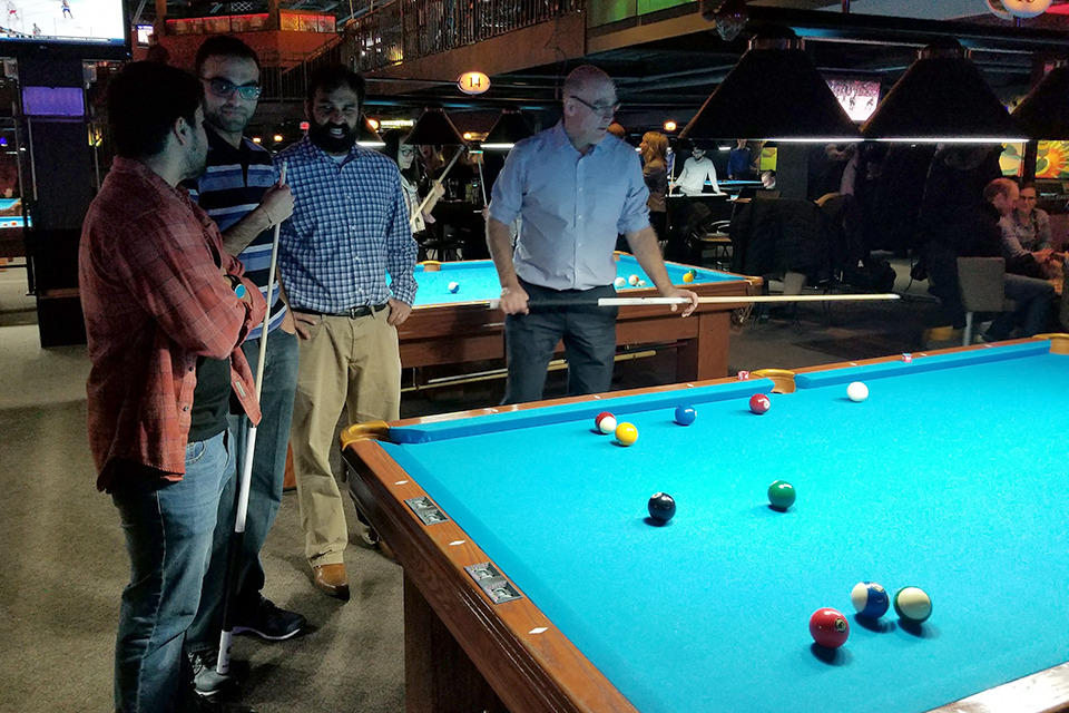 Four people playing pool
