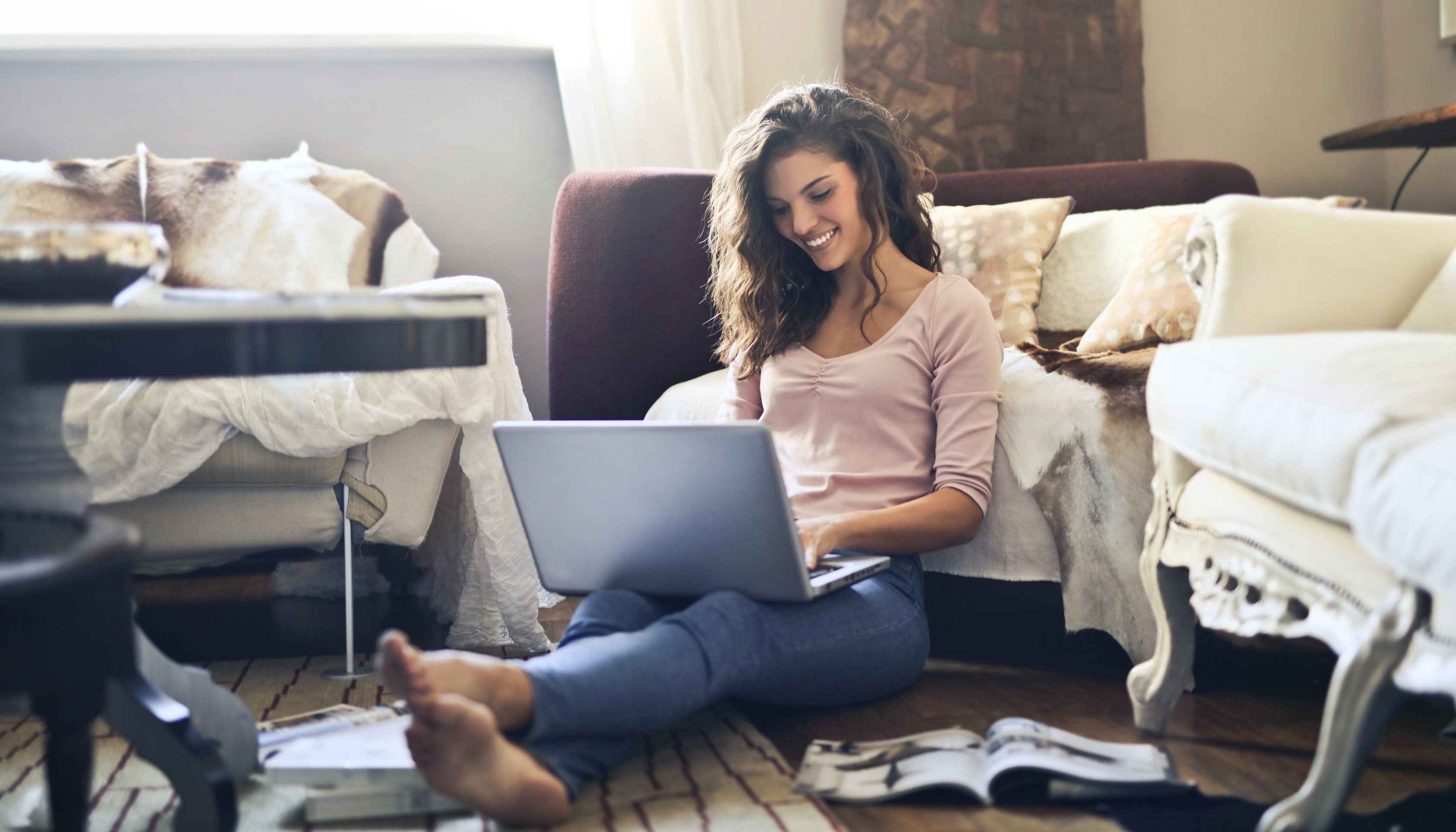 person working on a laptop sitting on the floor