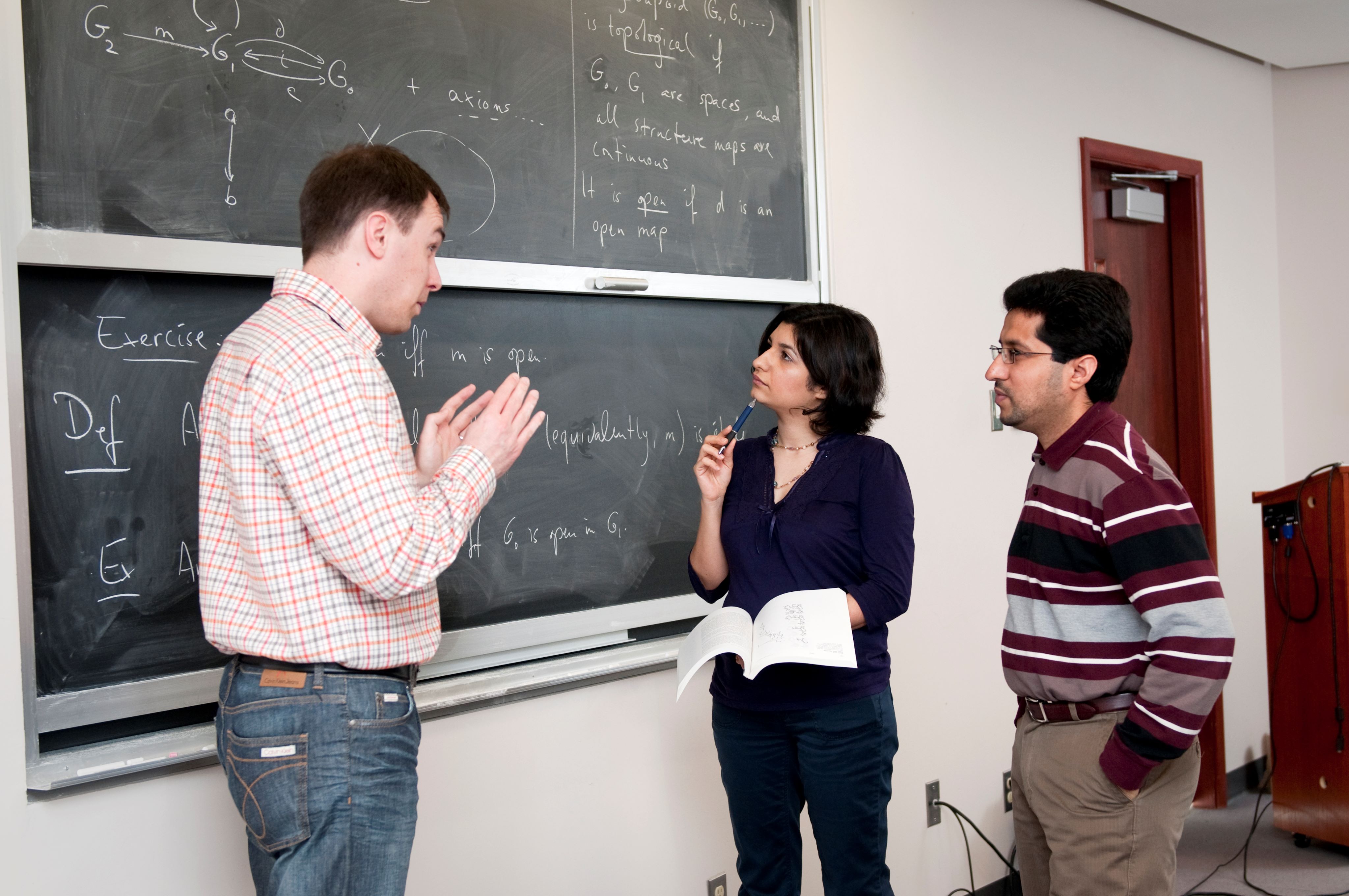 Teacher explaining math subject to two students