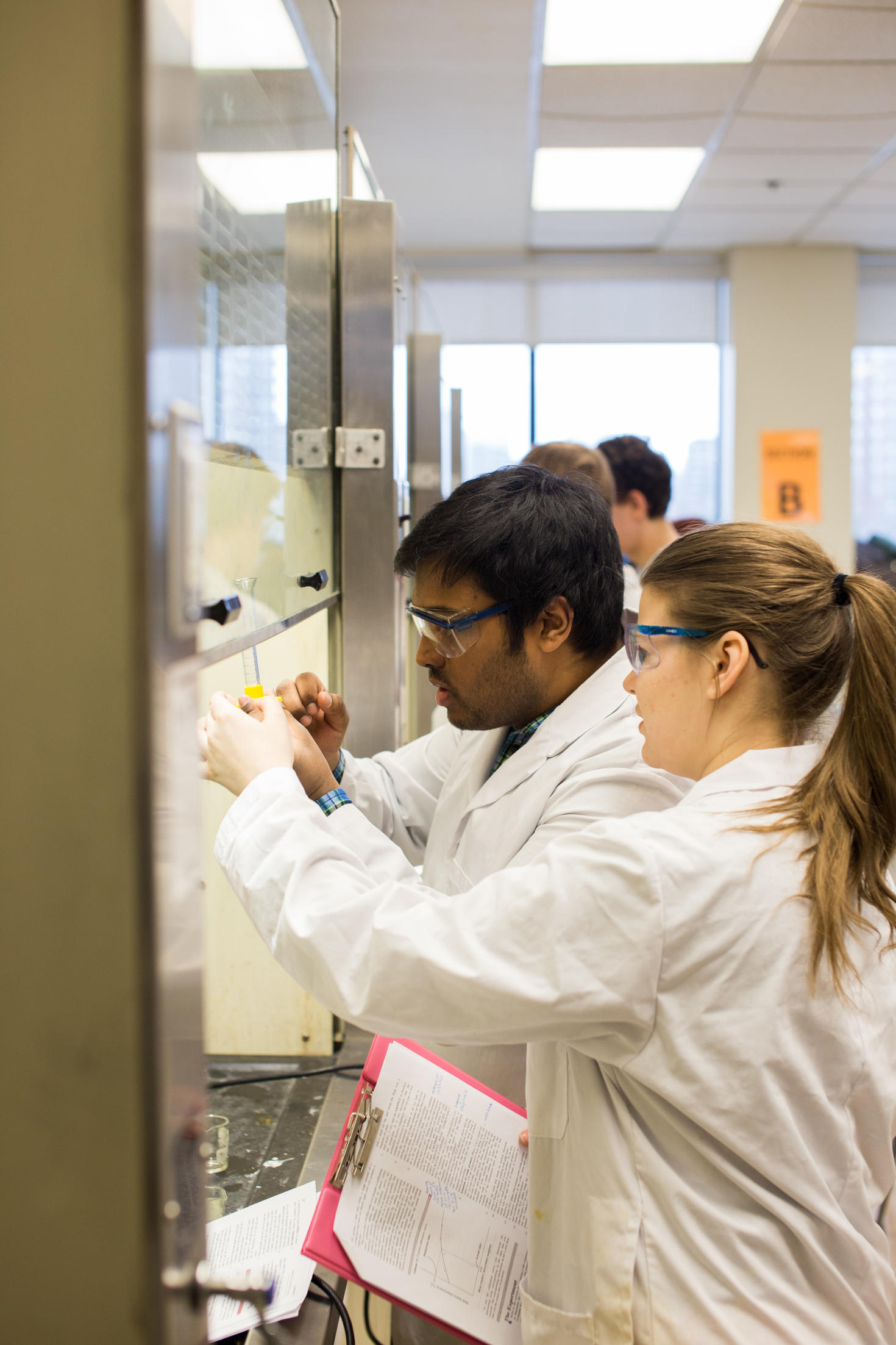 Two students working under a fumehood
