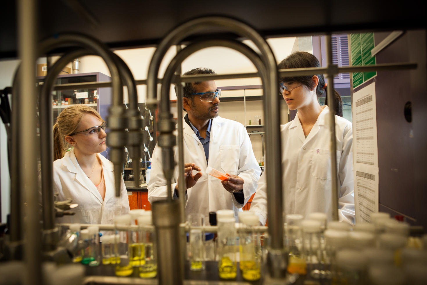 Professor Muralee Murugesu talking with students in a lab