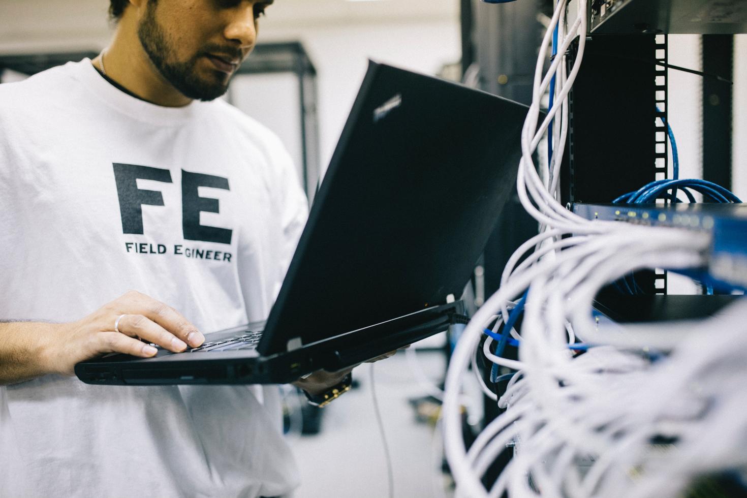 Student working on a laptop surrounded by wires