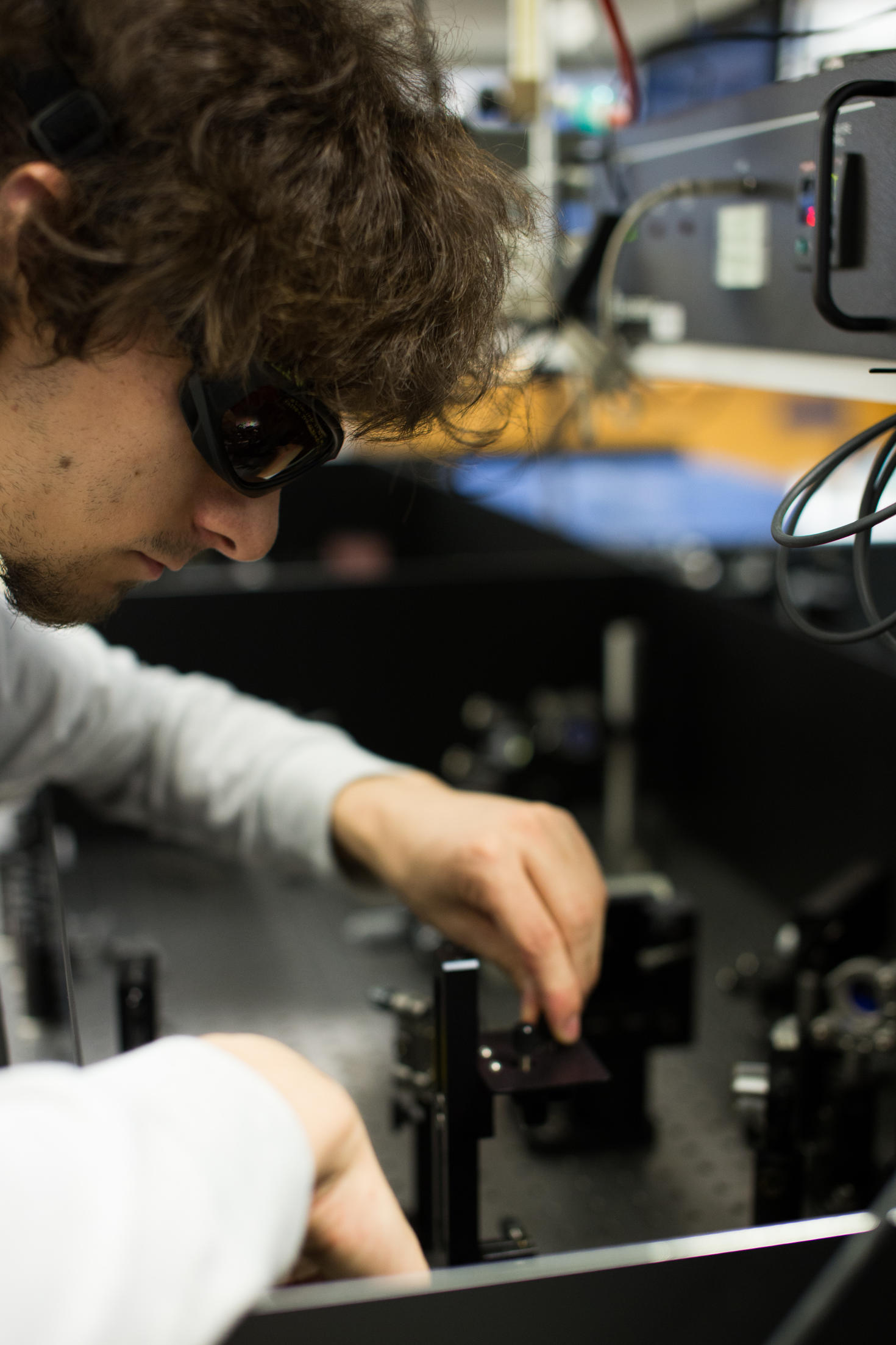 Student looking at physics lab instrument