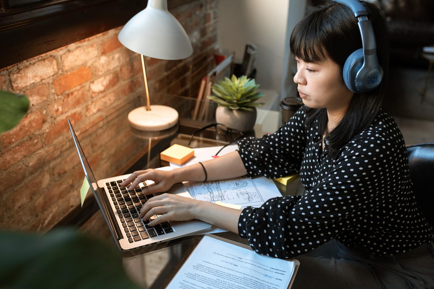 Female student is typiing on a laptop