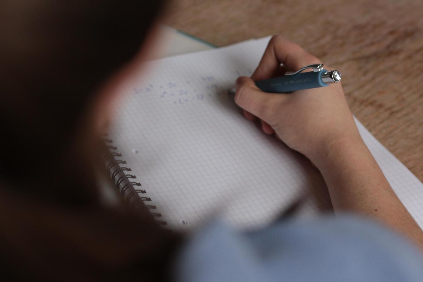 Close up on someone writing on paper