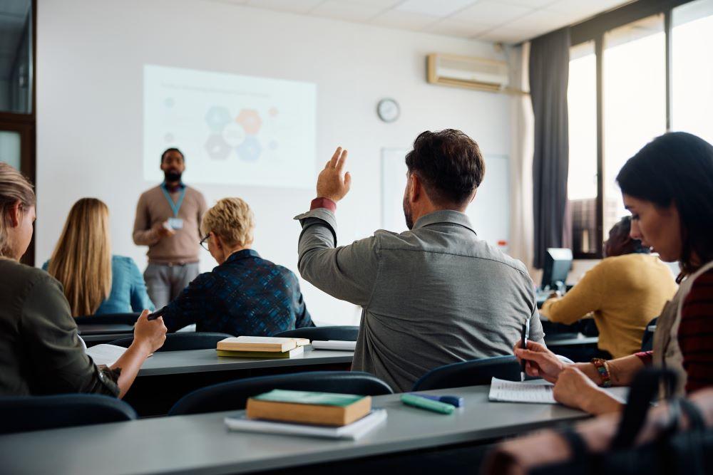 Man raising a hand in a classroom