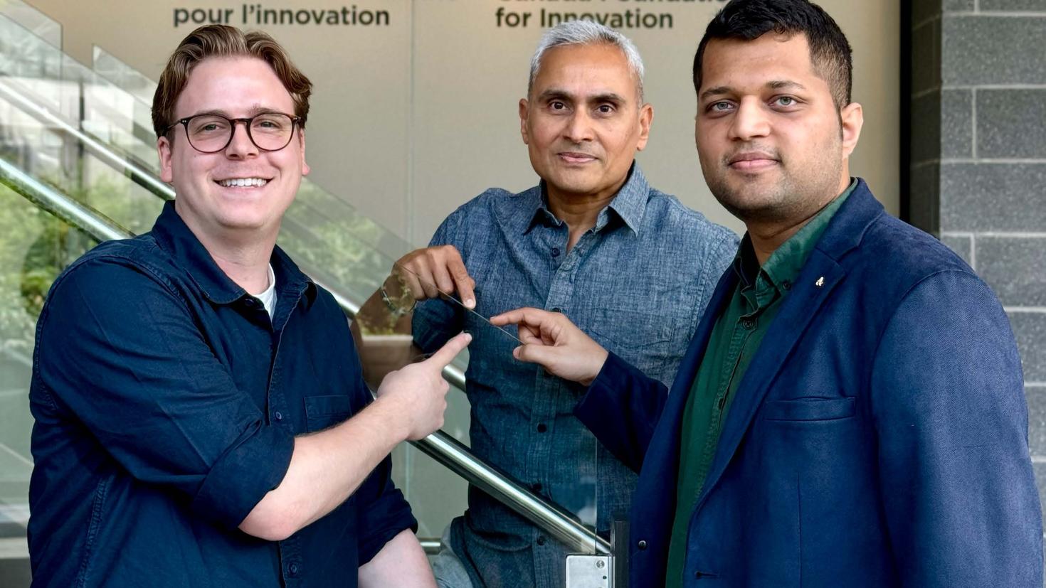 (From left to right) Jean-Luc Bégin, Professor Ravi Bhardwaj and Ashish Jain are standing in the uOttawa Advanced Research Complex, pointing to a glass railing. 
