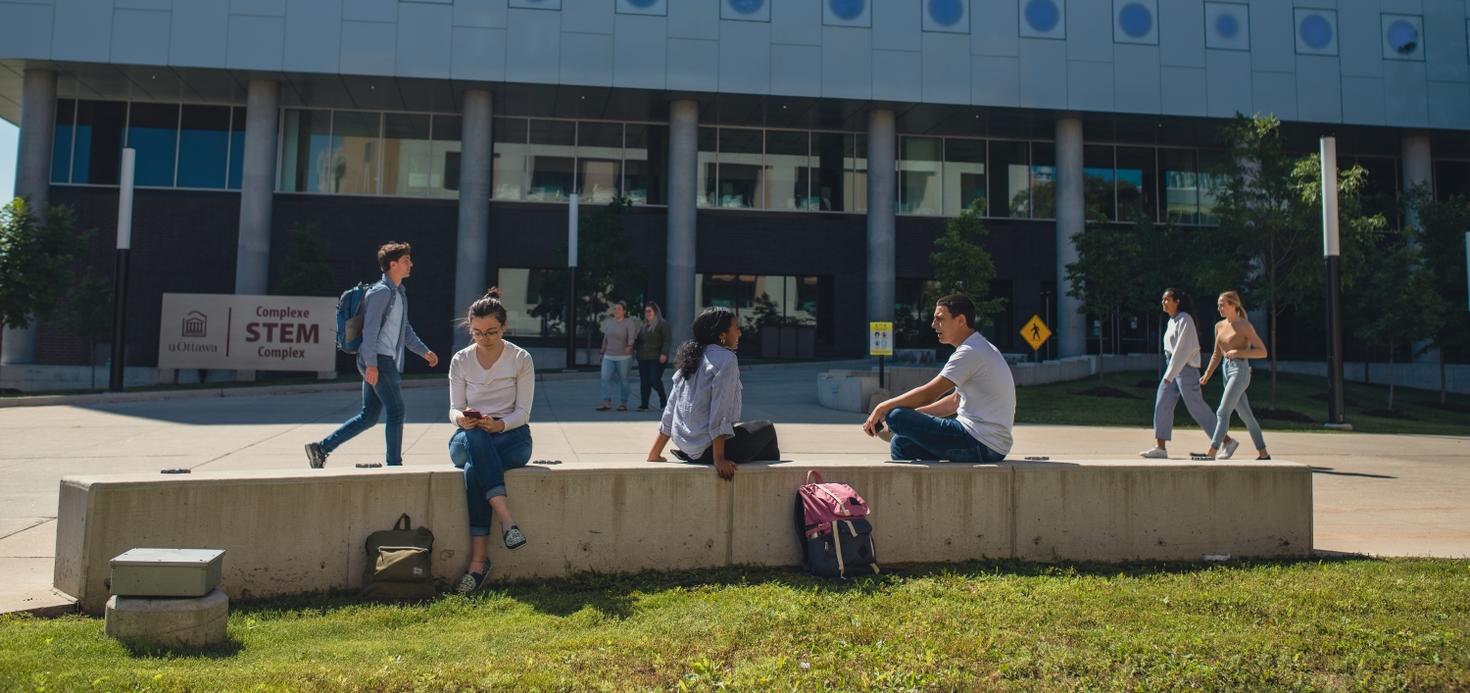 Students hanging out the STEM building in the summer