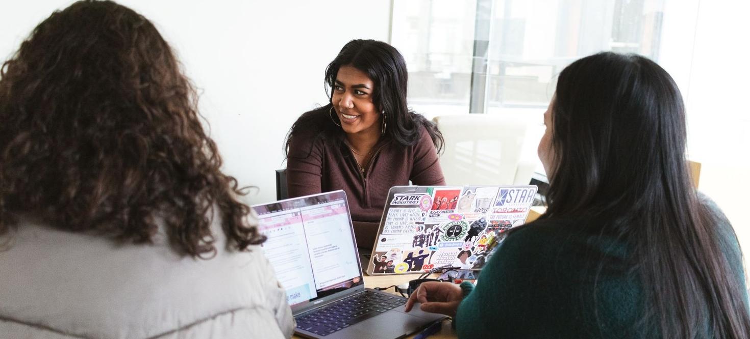 Group of female students talking around a table