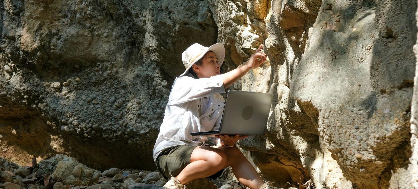 Female scientist looking upclose at rocks