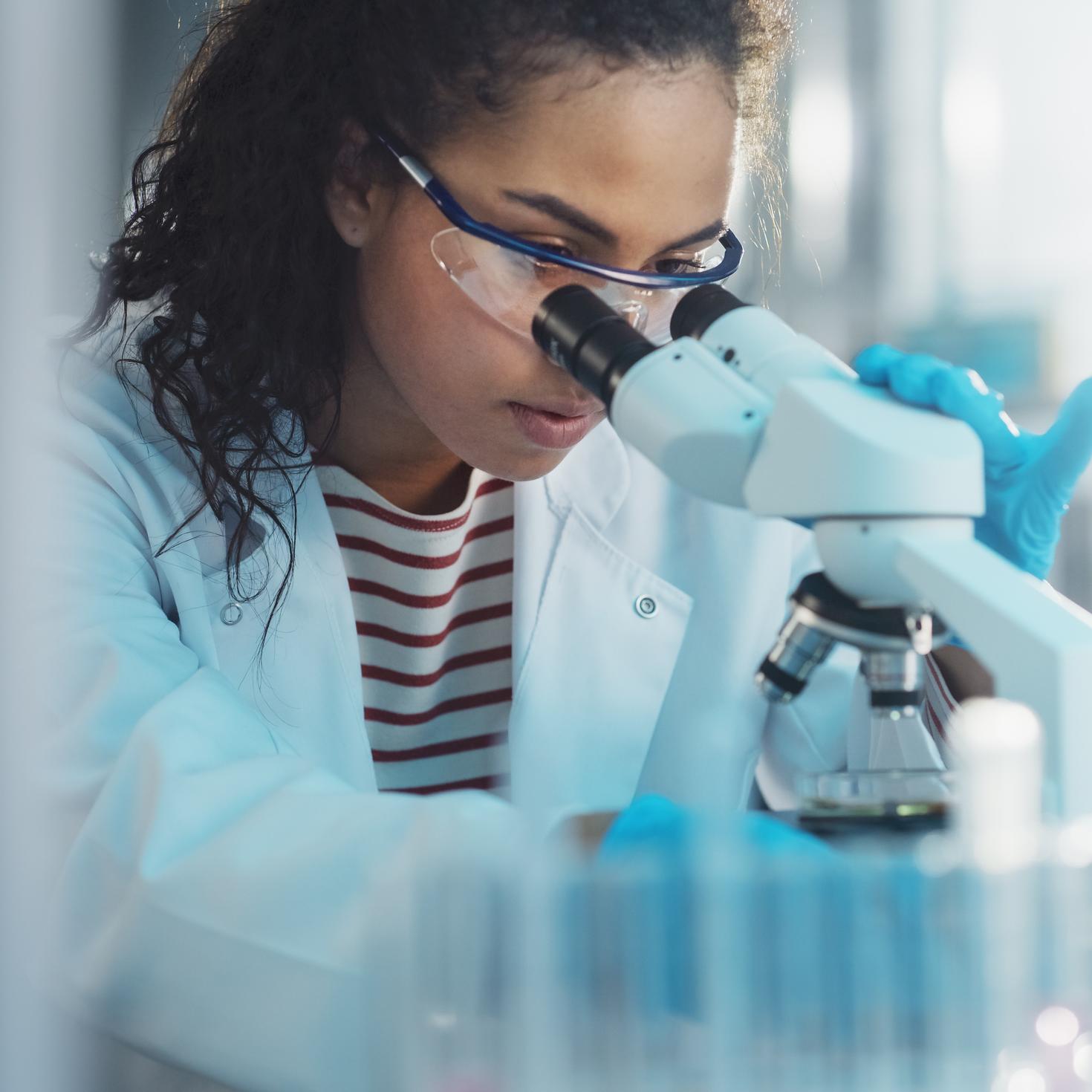 Female scientist looking through a microscope