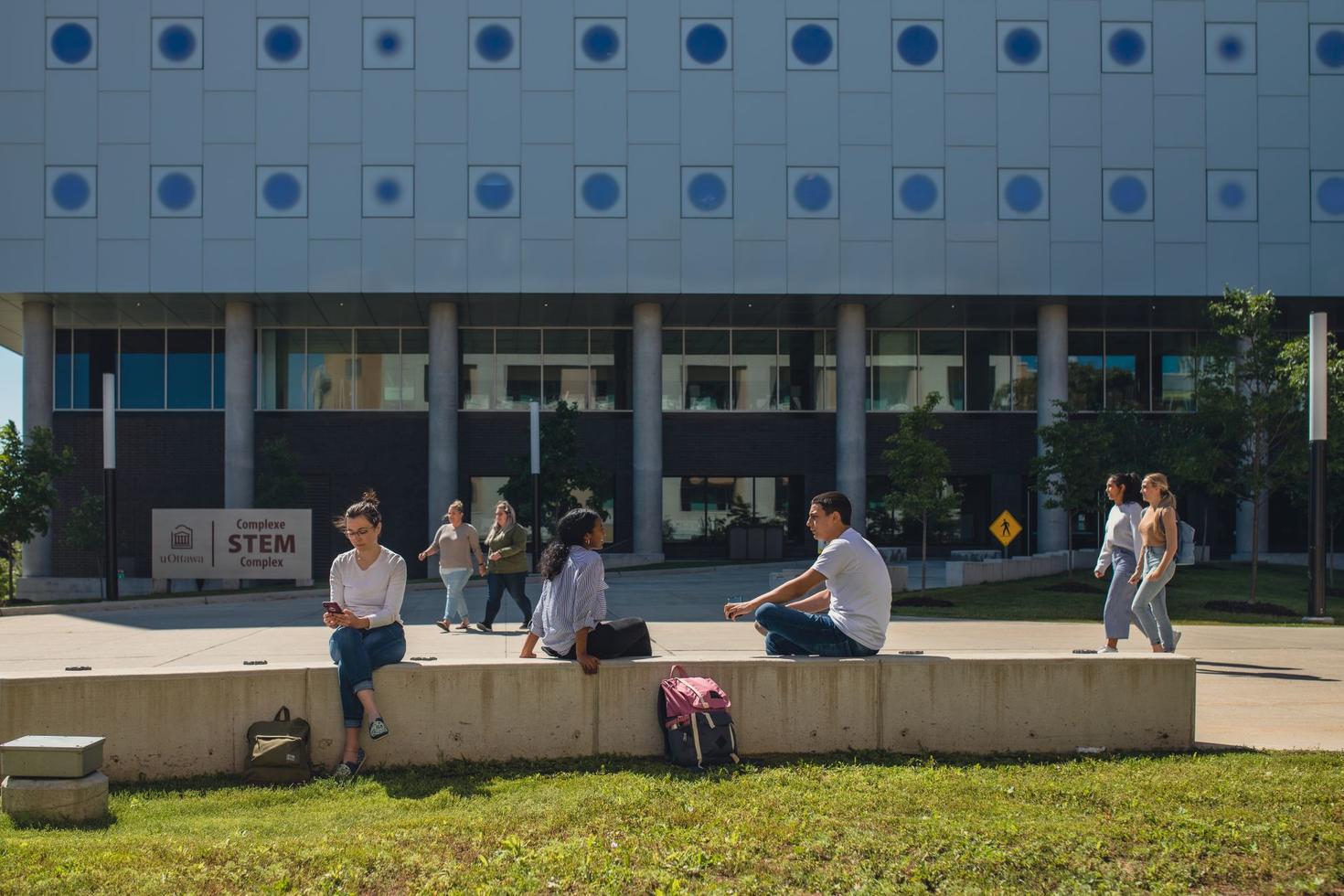 Students sittng outside in front of the STEM complex