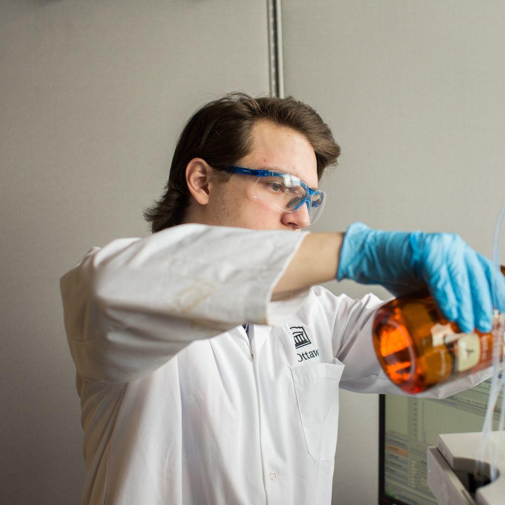 Student mesuring liquids in a lab. 