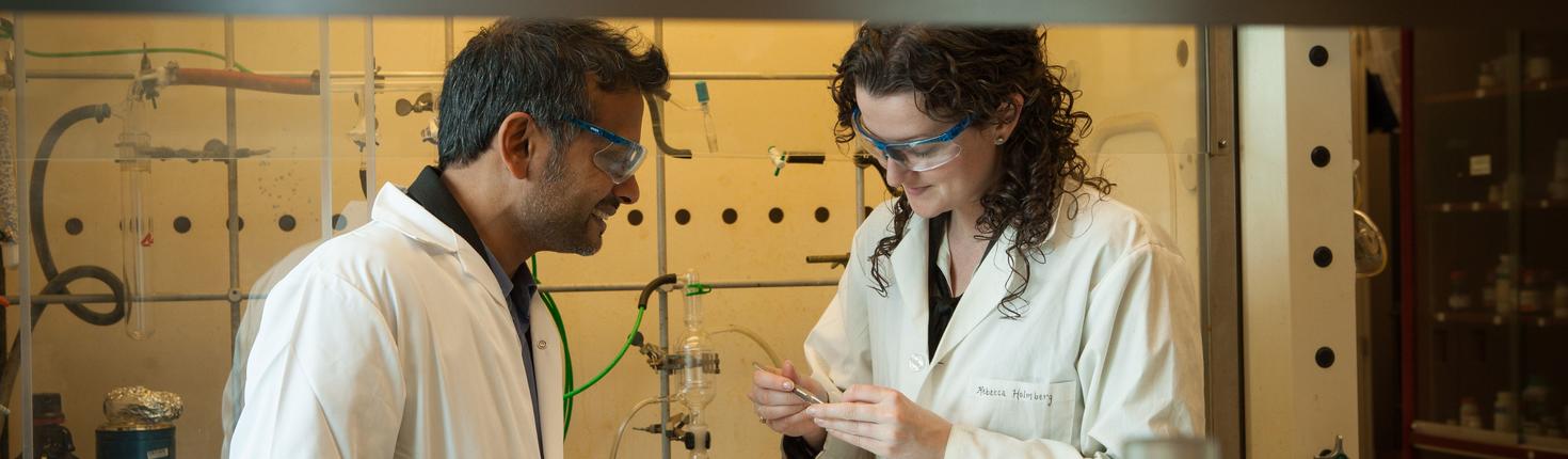 Professor Muralee Murugesu talking with graduate student in a lab. 