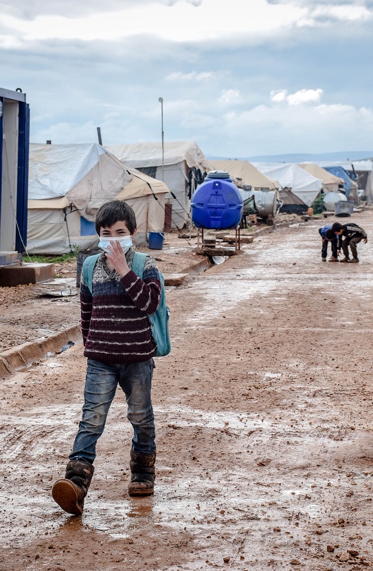 Child wearing mask in refugee camp
