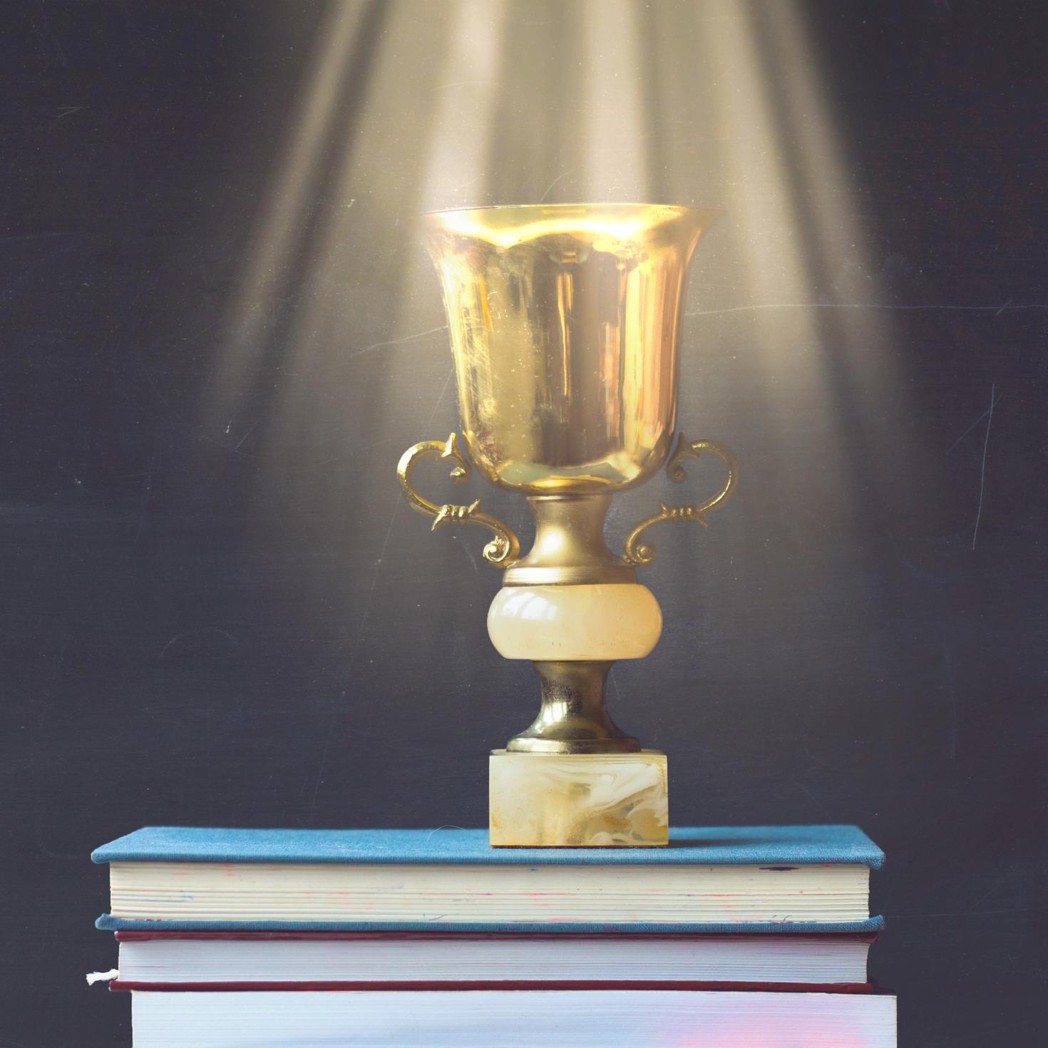 trophy on a stack of books