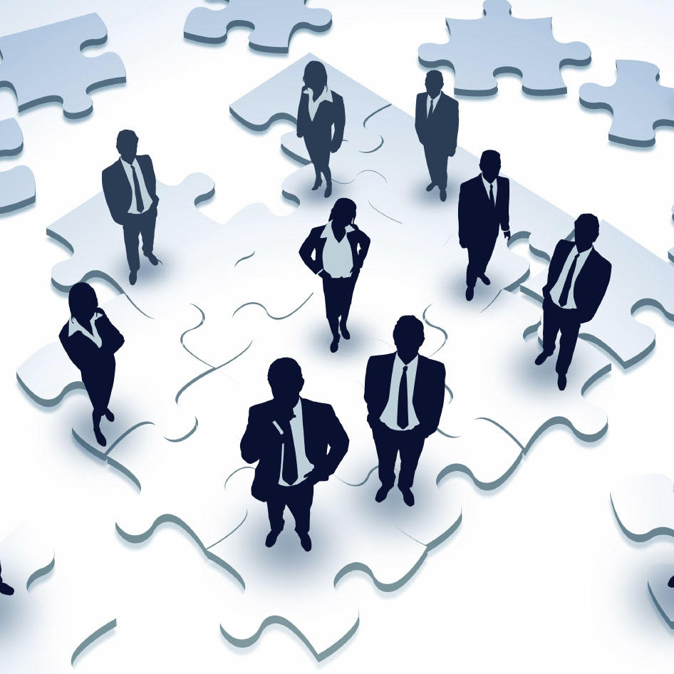 Business people in suits standing on a puzzle.