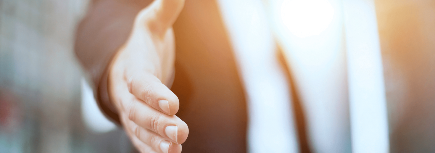 Professional reaching out to offer a handshake.