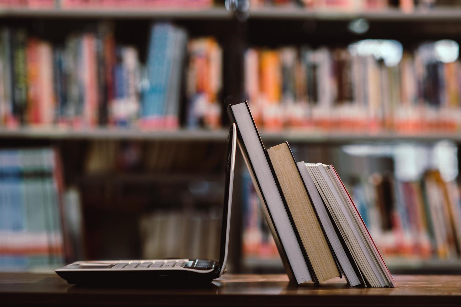 A laptop and books in a library