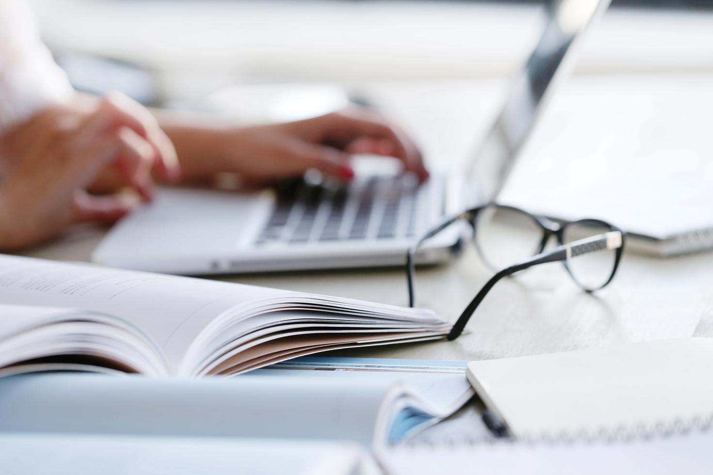 hands typing on laptop on office desk