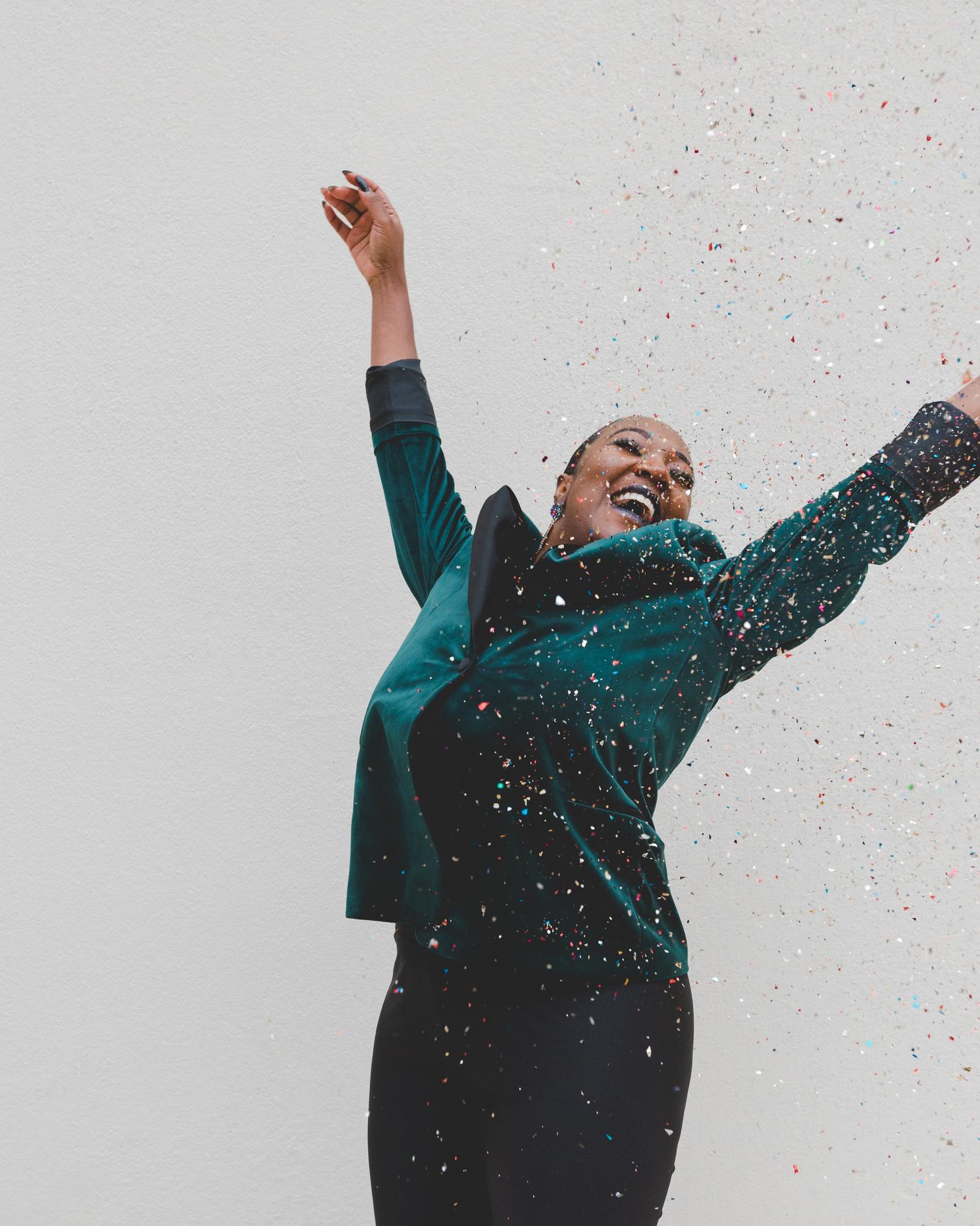 woman with green coat celebrating success
