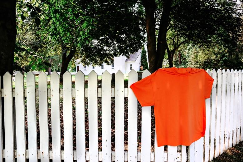 Orange shirt on a white fence