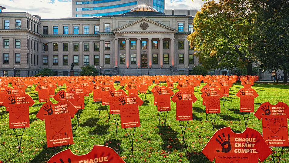 Orange t-shirts filling the lawn outside of Tabaret Hall