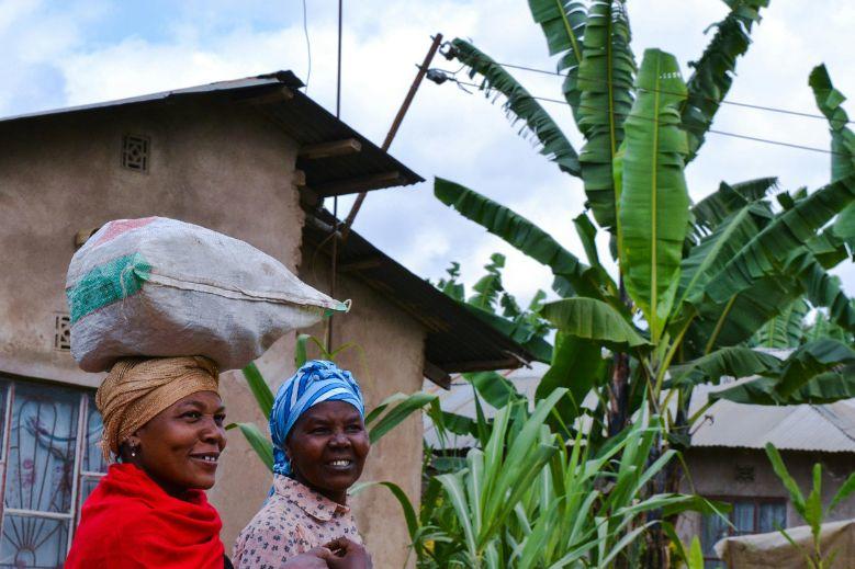 two women in Tanzania next to a large tree